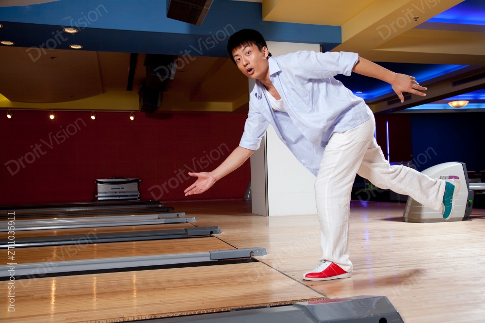 打保龄球的年轻男人图片