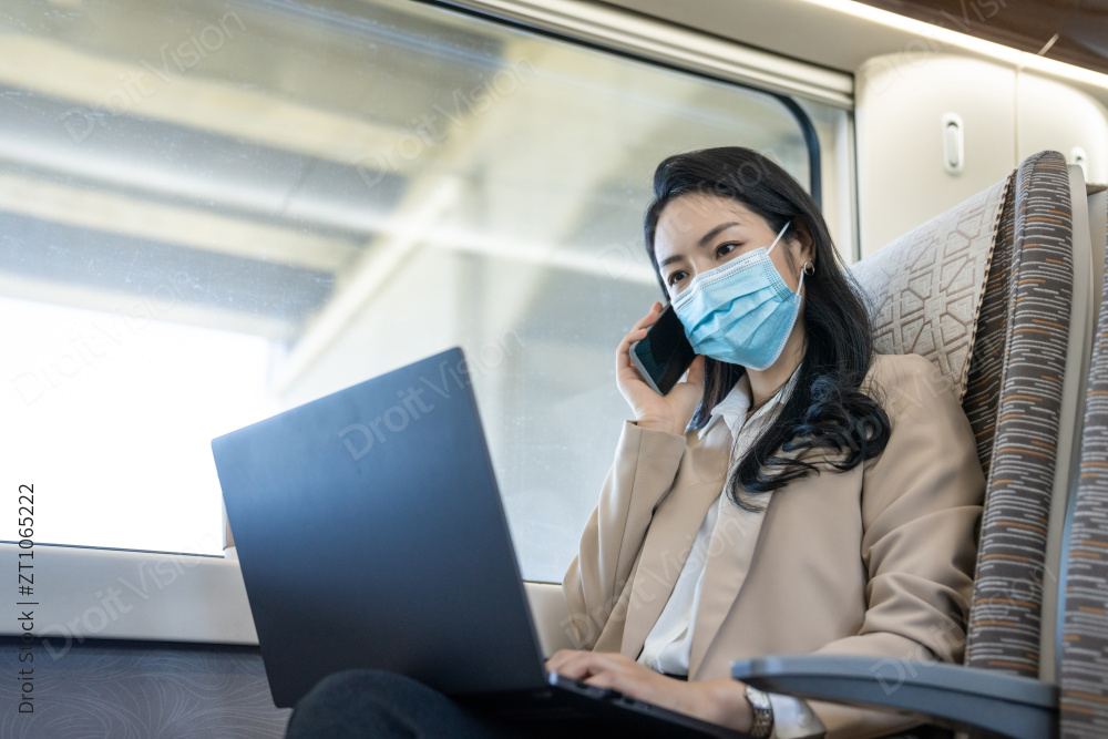 商务女士戴口罩乘坐地铁办公图片
