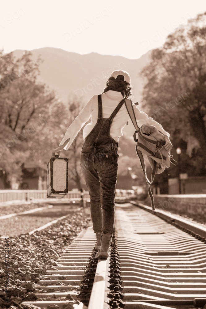 青年女人在铁轨上行走图片