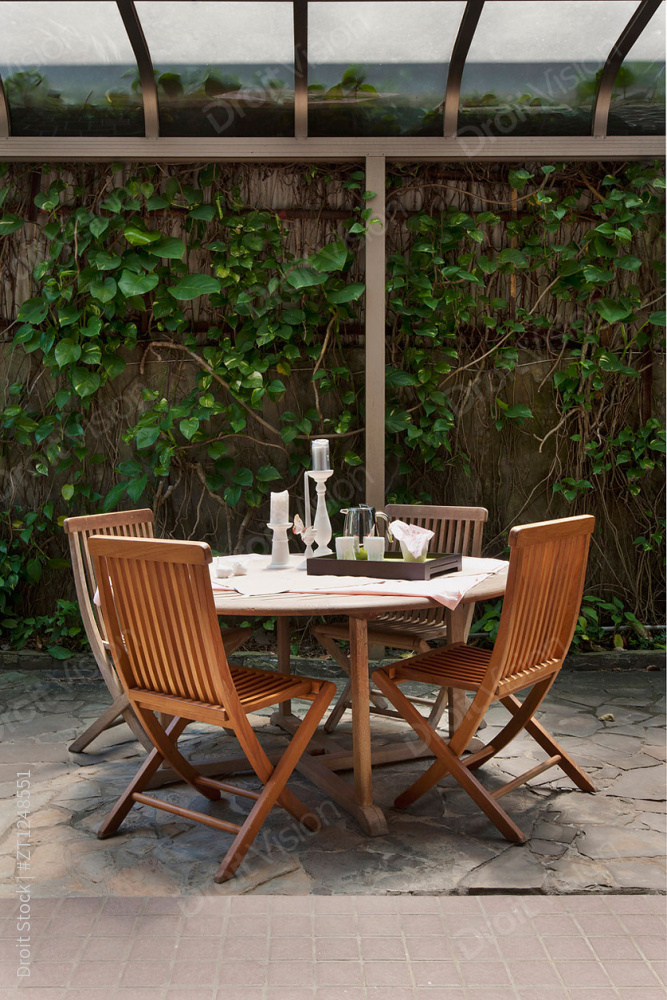 Veranda table and wooden chairs in house garden图片