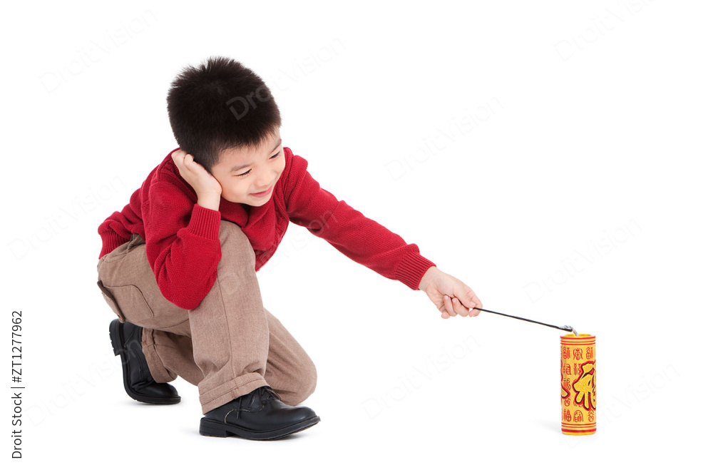 小男孩捂着耳朵燃放爆竹图片