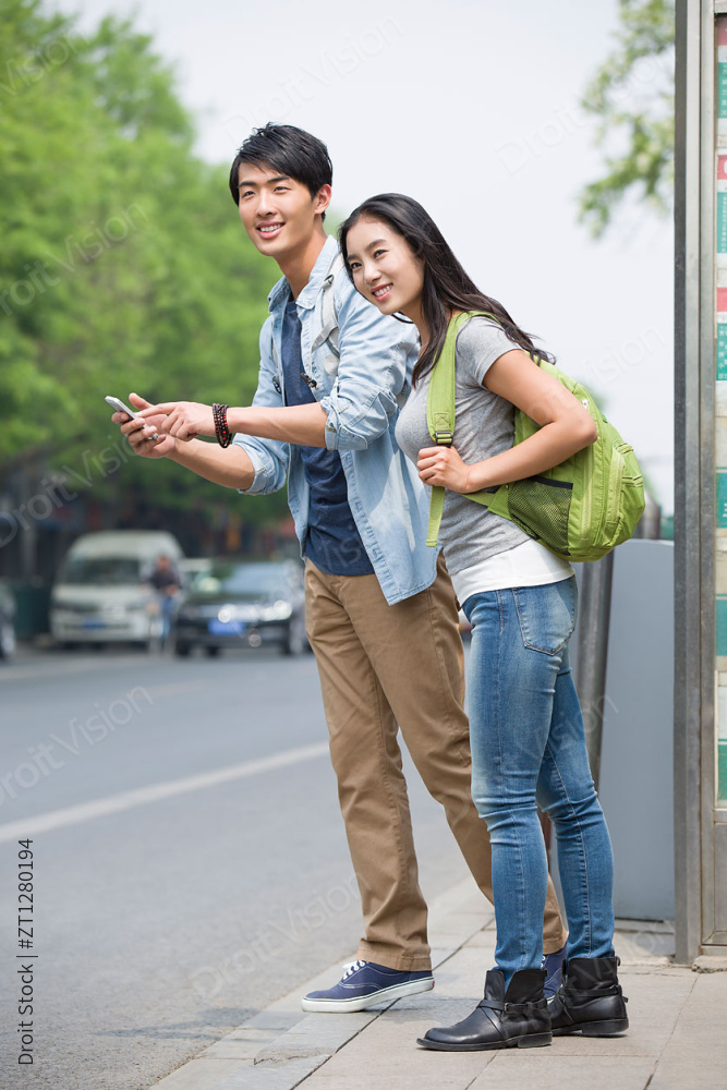 年轻情侣在公交站等车图片