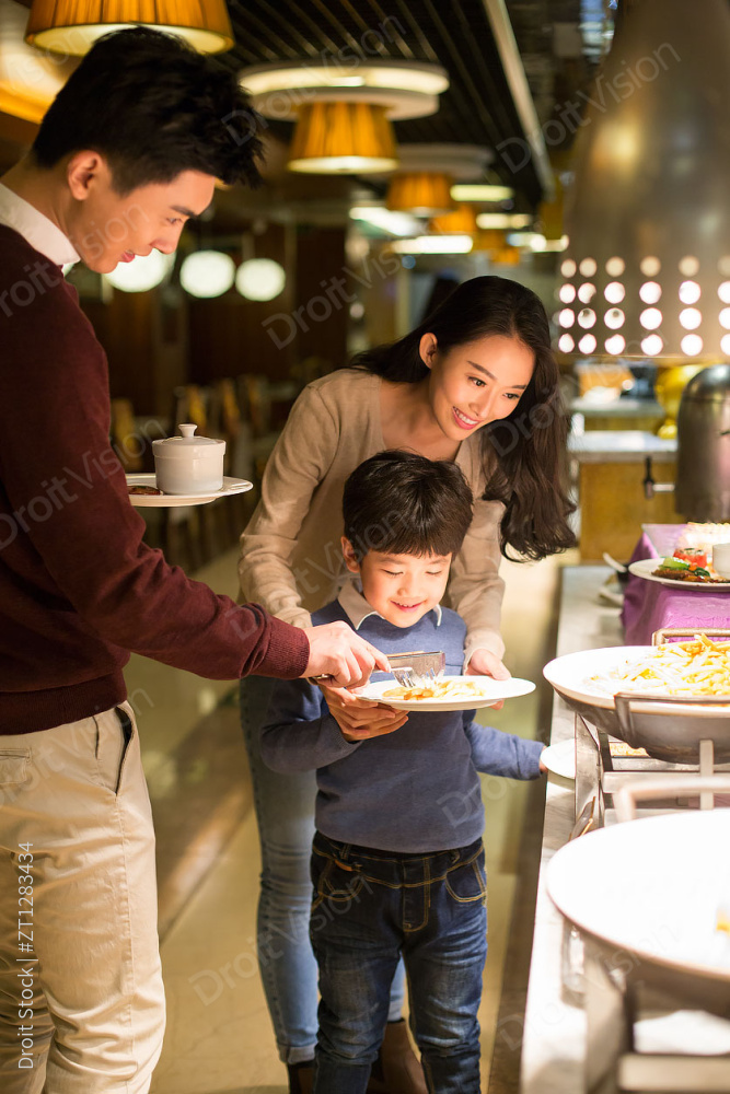 开心的年轻家庭挑选自助餐图片