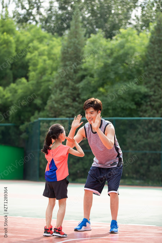 快乐的父女俩在运动场打篮球图片