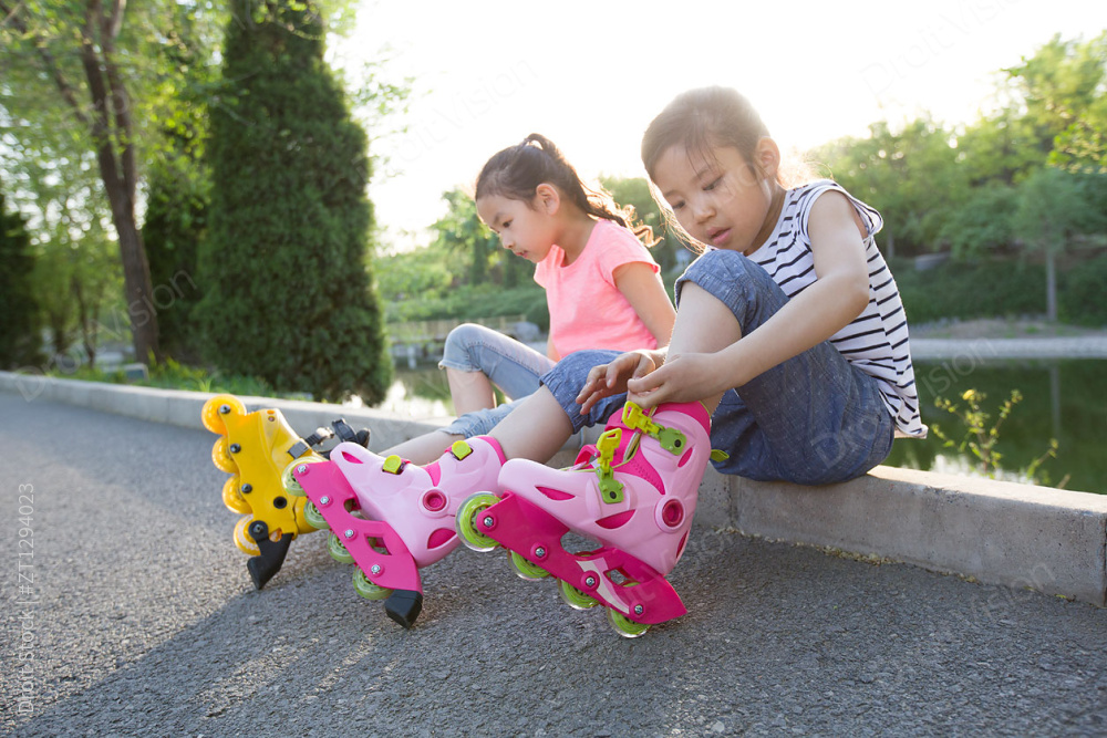 儿童坐在路边穿直排轮鞋图片
