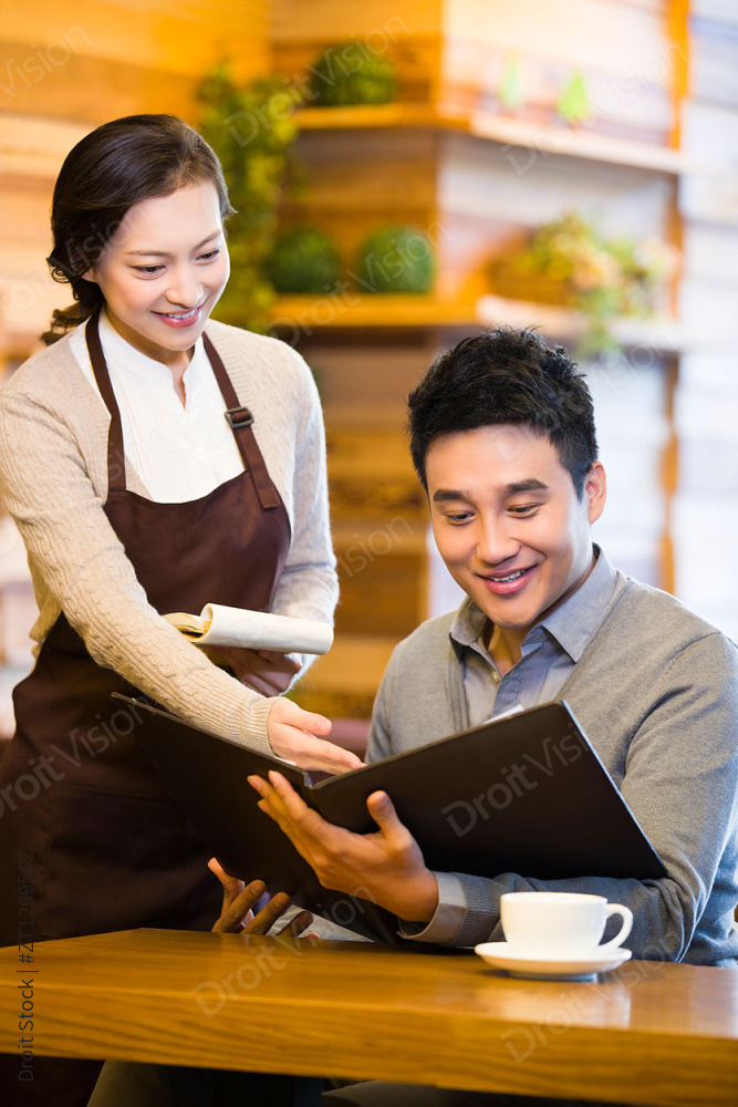 女服务员向顾客介绍菜单图片