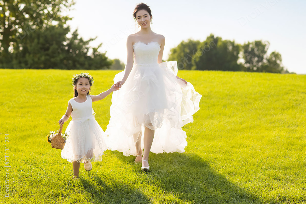 可爱的婚礼花童和新娘在草地上玩图片