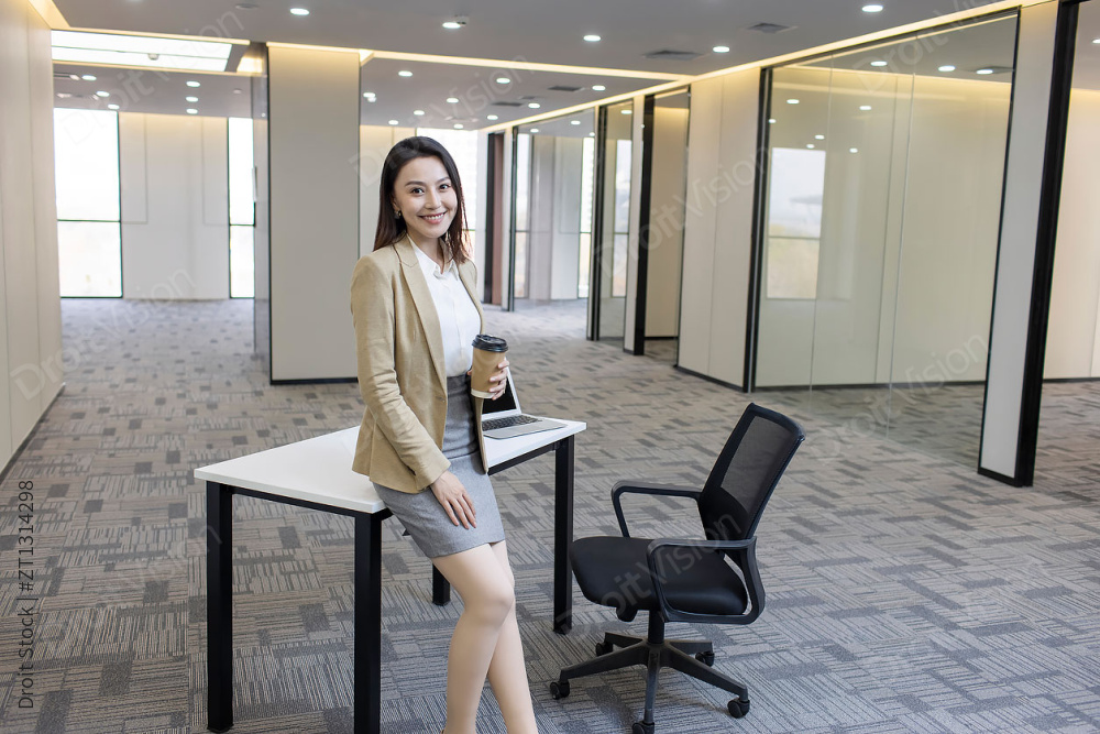 商务女士在空旷的办公室里喝咖啡图片