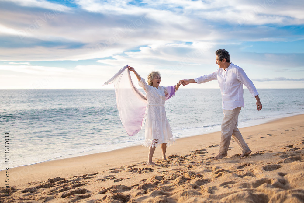 快乐的老年夫妇在沙滩跳舞图片