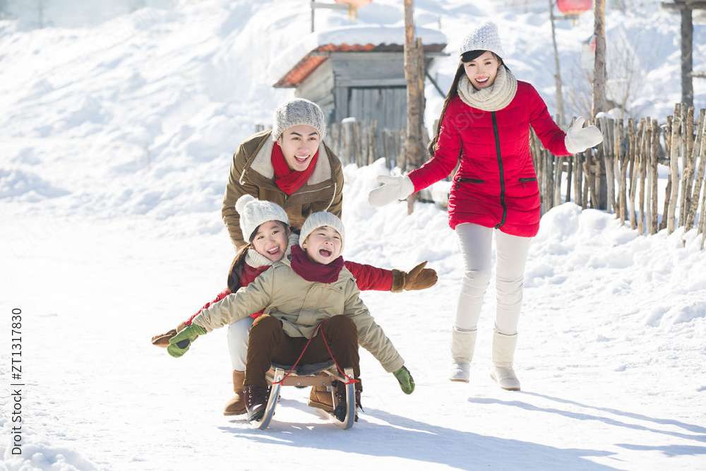 快乐的一家人在雪地上玩雪橇图片