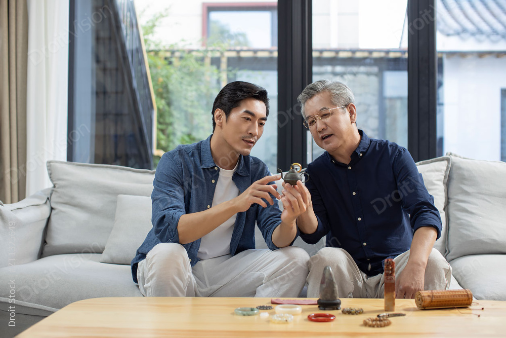 中年男子和父亲在家里鉴定古董图片