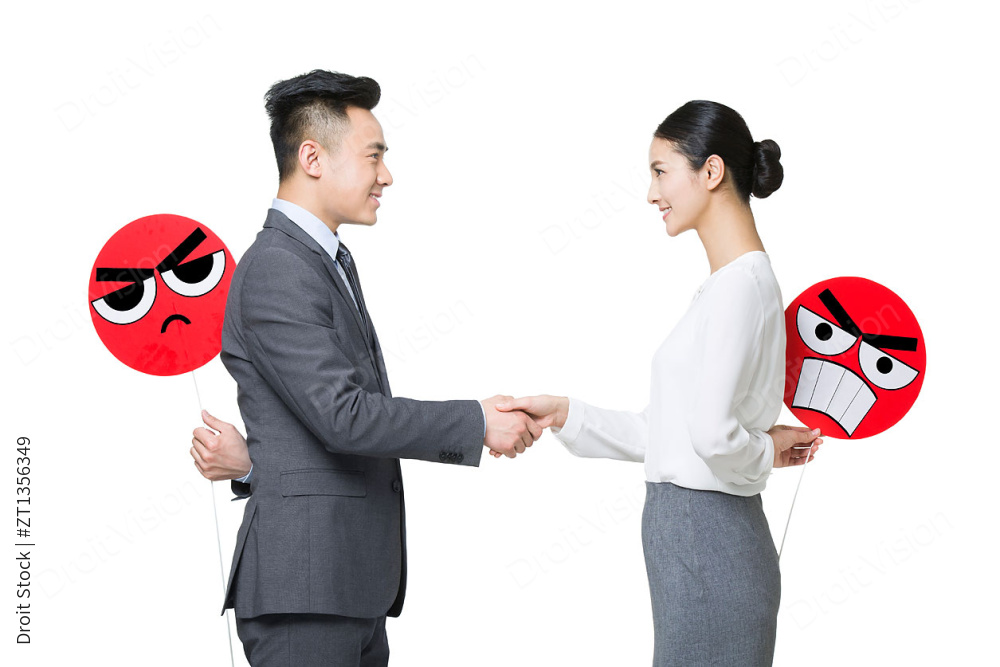 商务人士虚情假意地握手图片