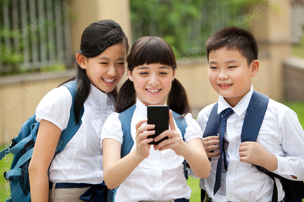兴奋的小学生玩手机图片