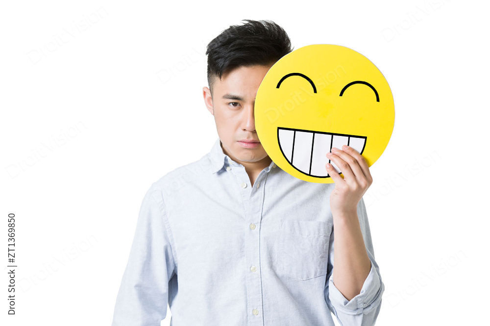 年轻男子拿着一张卡通笑脸图片