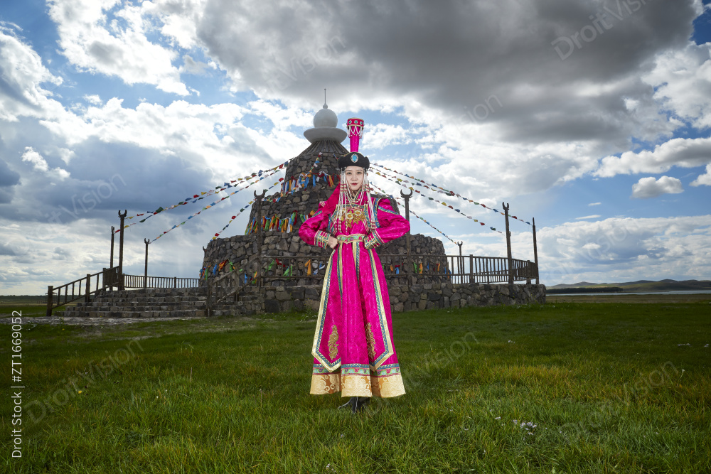 草原上敖包前身穿豪华蒙古族服饰的蒙族少女图片