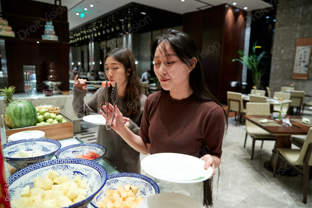 在酒店自助餐厅大吃特吃的亚洲可爱闺蜜少女图片
