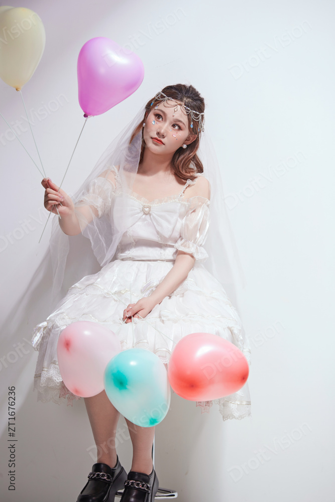 穿着公主裙手拿气球庆祝生日的亚洲女性图片