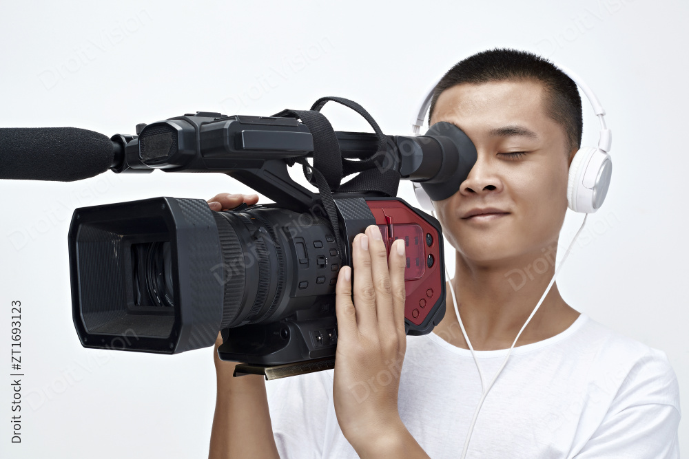 白色背景下手持摄像机进行录制拍摄的摄像师图片