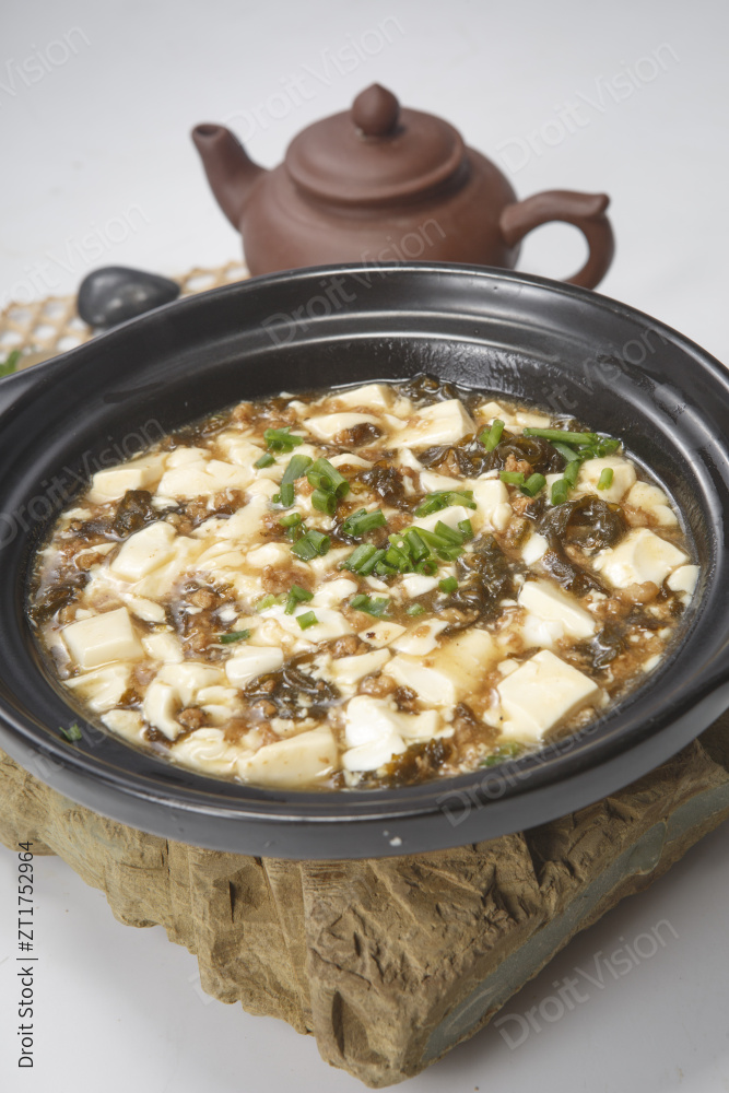 黑色砂锅装的酸豆角豆腐煲图片