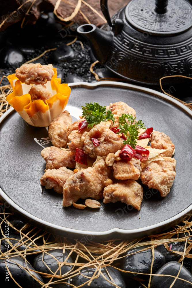 黑色陶餐具装的香炸三黄鸡块图片