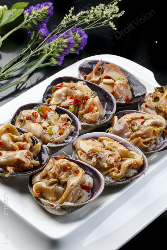 鼎形瓷盘装的海鲜炭烤紫石房蛤天鹅蛋图片