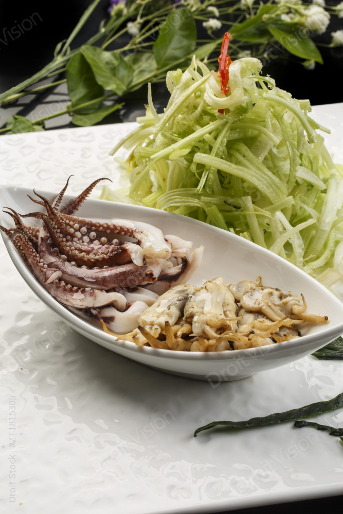 白色方形瓷盘装的西芹拌海鲜图片