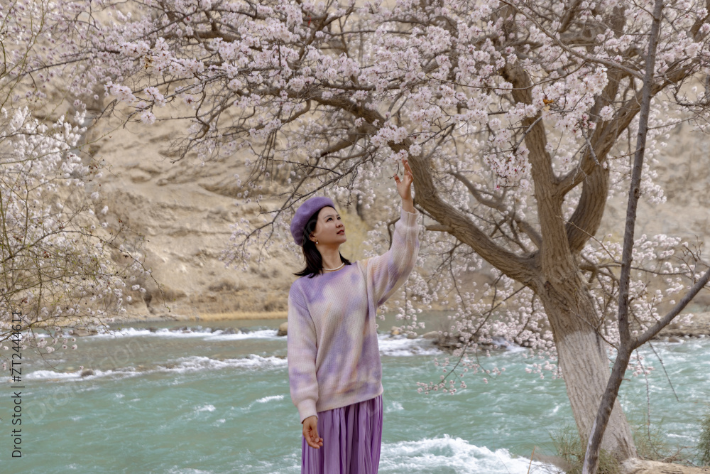 站在湖边杏花树下的女人图片