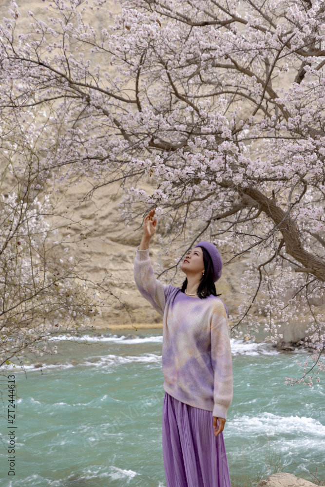 站在湖边杏花树下的女人图片
