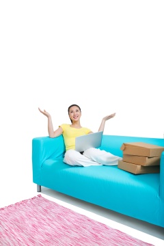 棚拍年轻女人坐在沙发上上网购物