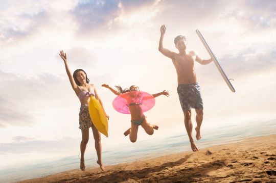 沙滩上跳跃的快乐三口之家