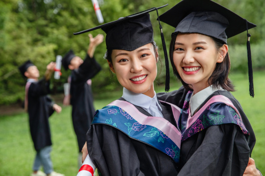 户外穿着学士服的大学生们