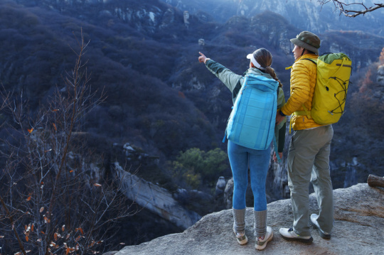 青年登山者伴侣站在山顶俯瞰