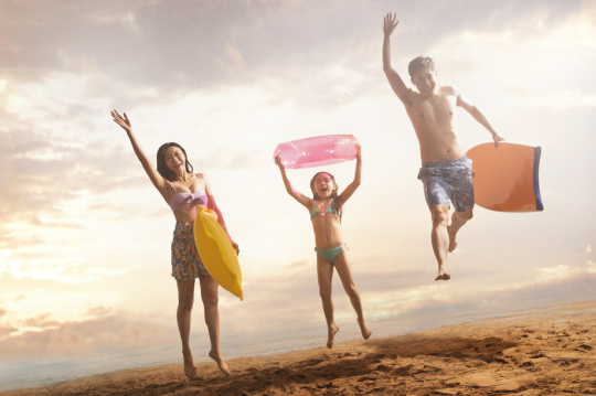 沙滩上跳跃的快乐三口之家