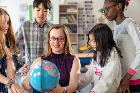教师辅导小学生在教室里学习