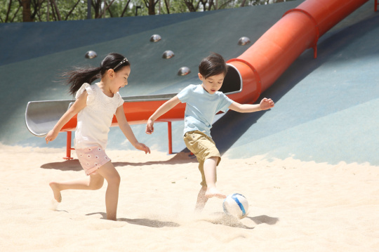 儿童在沙子里踢球