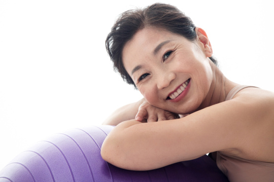 中年女性趴在瑜伽球上