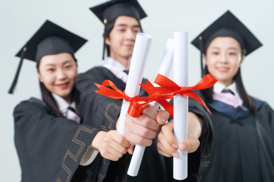 身穿学士服的毕业大学生拿着文凭