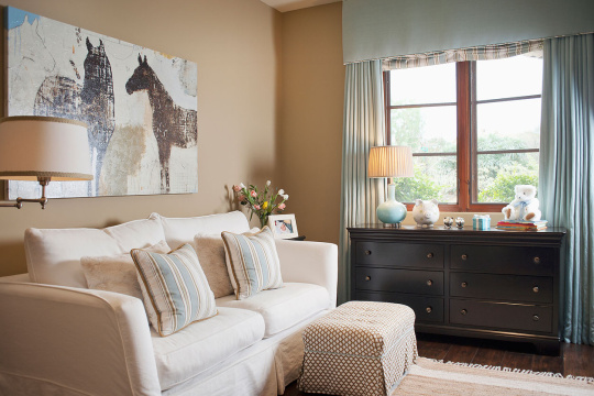 Sofa set with random objects on end table against window in living room at house