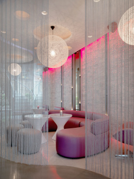 Lounge area through string curtains in modern nightclub