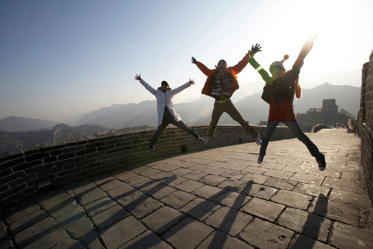 年轻男女在长城欢呼跳跃