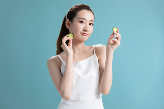 年轻美女拿着黄瓜片