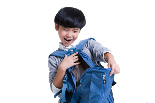 惊讶的小男孩打开书包