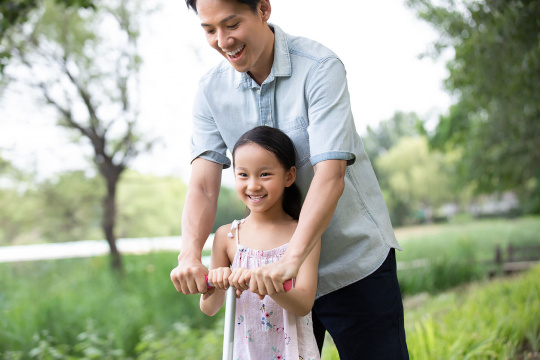 父女俩人在公园玩滑板车