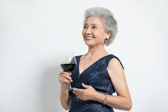 老年女士拿着一杯红酒