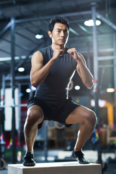 年轻男子在健身房做跳箱运动