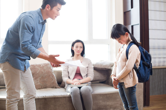 女孩拿着不及格的成绩单放学回家