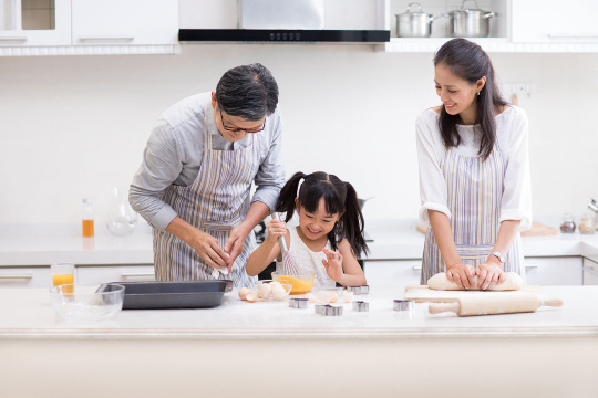 快乐小女孩和爷爷奶奶在厨房制作饼干