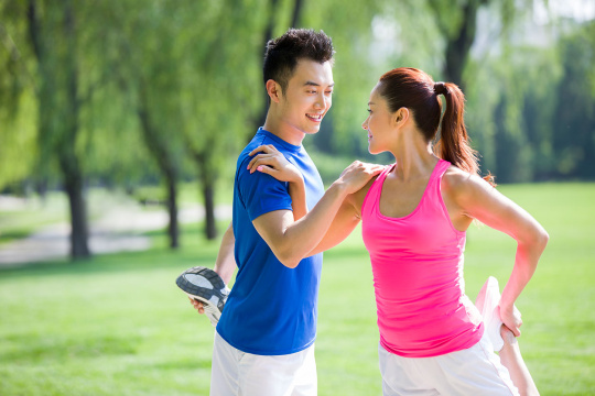 年轻情侣在公园锻炼热身