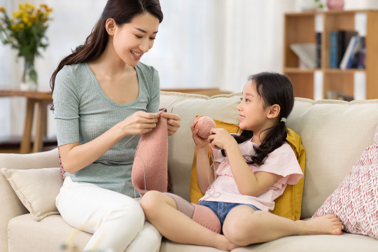 快乐的母女俩在家织围巾