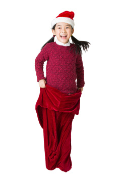 小女孩套着圣诞礼物袋蹦跳